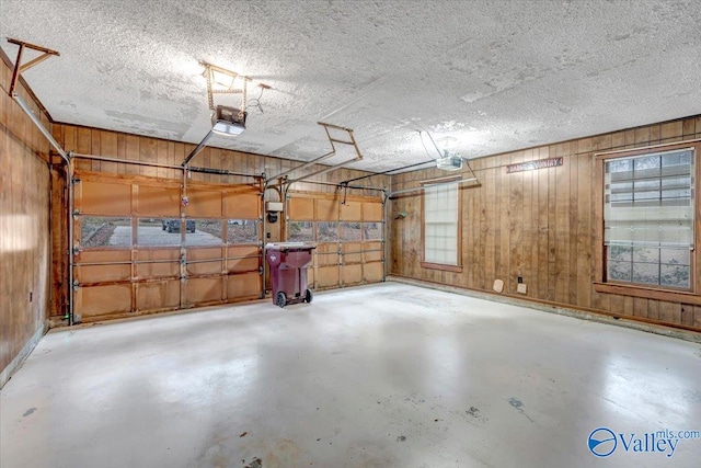 garage featuring wood walls and a garage door opener