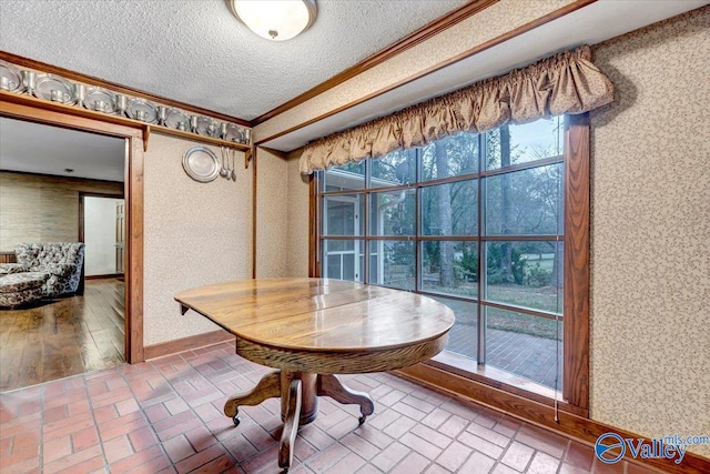 dining room with ornamental molding and a textured ceiling