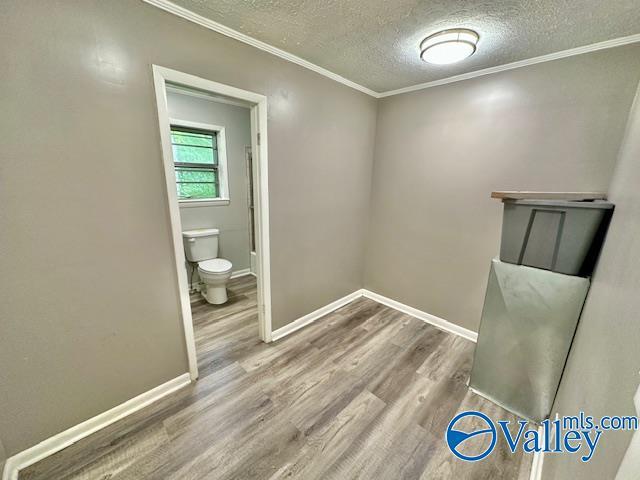 196 Johnson St, Rainsville, AL 35986 - bathroom with wood finished floors, toilet, a textured ceiling, ornamental molding, and baseboards