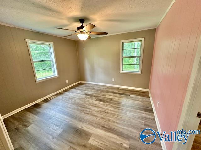 196 Johnson St, Rainsville, AL 35986 - spare room featuring plenty of natural light, a textured ceiling, crown molding, wood finished floors, and a ceiling fan