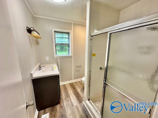 196 Johnson St, Rainsville, AL 35986 - bathroom featuring vanity, wood finished floors, a shower stall, ornamental molding, and toilet