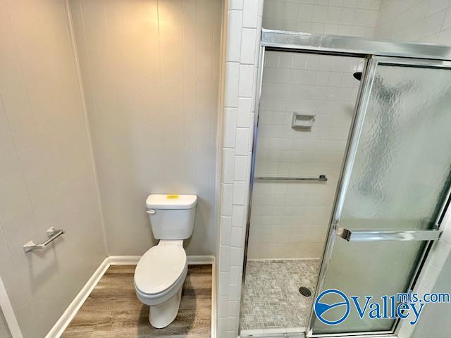 196 Johnson St, Rainsville, AL 35986 - full bath with toilet, wood finished floors, a shower stall, and baseboards