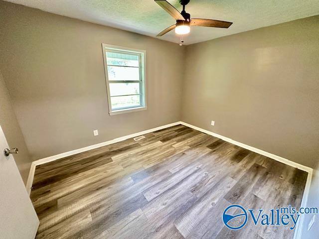 196 Johnson St, Rainsville, AL 35986 - unfurnished room with a ceiling fan, wood finished floors, baseboards, and a textured ceiling