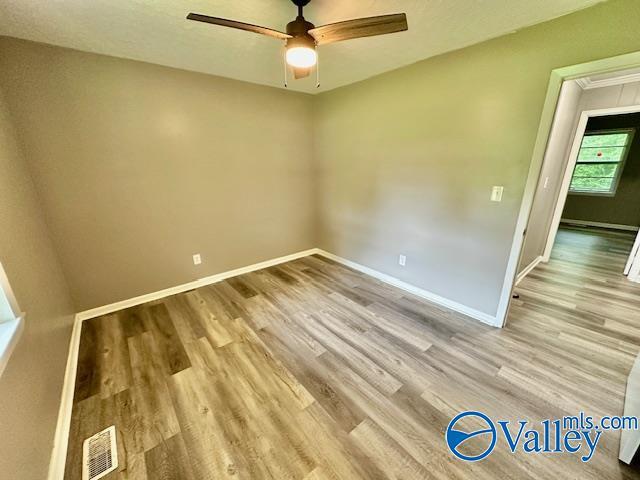 196 Johnson St, Rainsville, AL 35986 - empty room with light wood-style floors, a ceiling fan, baseboards, and attic access