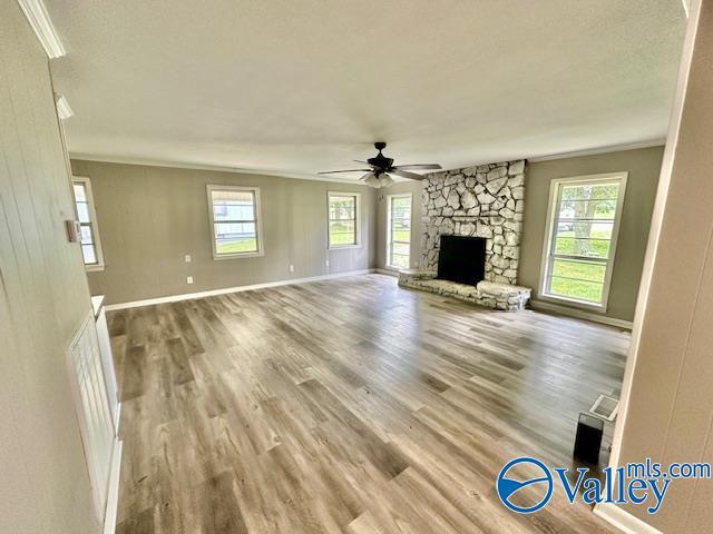 196 Johnson St, Rainsville, AL 35986 - unfurnished living room featuring ornamental molding, wood finished floors, a ceiling fan, plenty of natural light, and baseboards