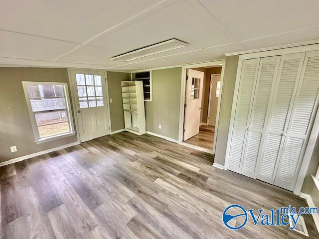 196 Johnson St, Rainsville, AL 35986 - unfurnished living room featuring attic access, wood finished floors, and baseboards