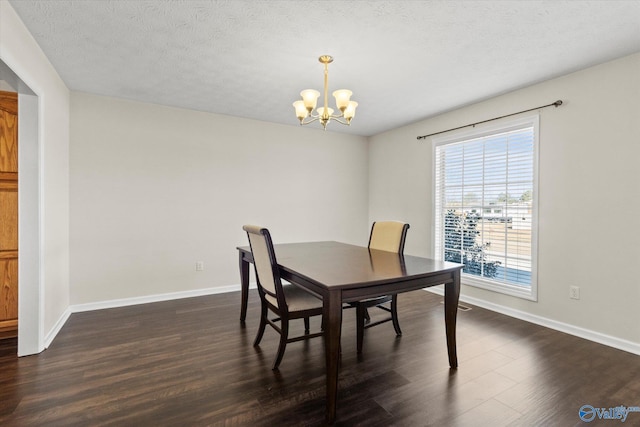 dining space featuring a textured ceiling, dark hardwood / wood-style flooring, and a chandelier