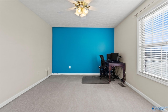 unfurnished office featuring ceiling fan and light colored carpet