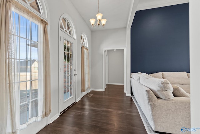 entrance foyer with dark hardwood / wood-style flooring, a chandelier, and a healthy amount of sunlight