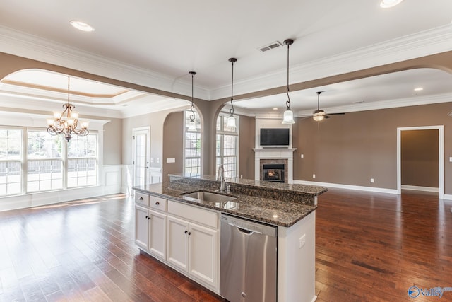 kitchen featuring white cabinets, a center island with sink, dark stone countertops, dishwasher, and sink