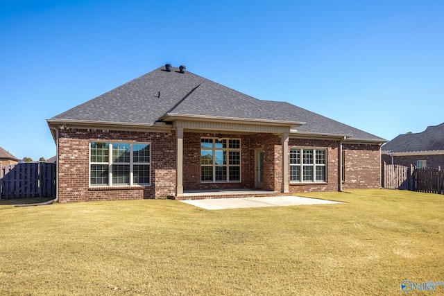 back of house with a patio area and a lawn