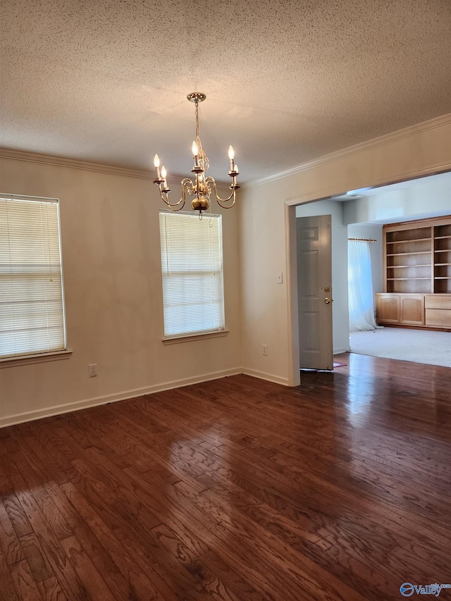 unfurnished room featuring a textured ceiling, dark hardwood / wood-style flooring, ornamental molding, and a notable chandelier