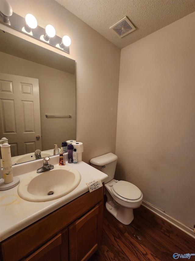 bathroom featuring hardwood / wood-style floors, vanity, a textured ceiling, and toilet