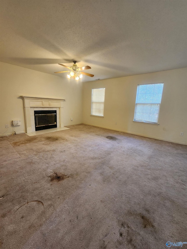 unfurnished living room with light carpet, a textured ceiling, and ceiling fan