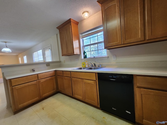 kitchen featuring pendant lighting, dishwasher, sink, and a textured ceiling