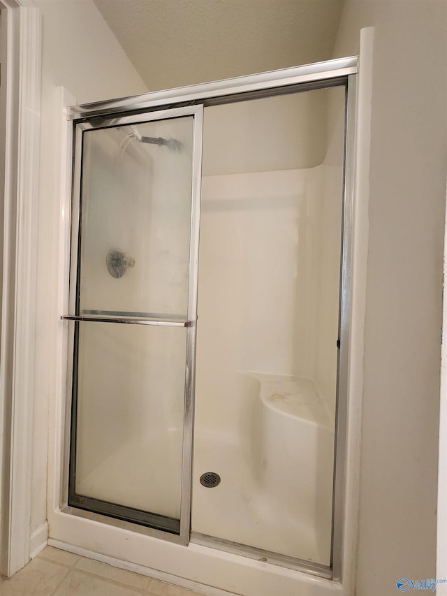 bathroom featuring tile patterned flooring and an enclosed shower