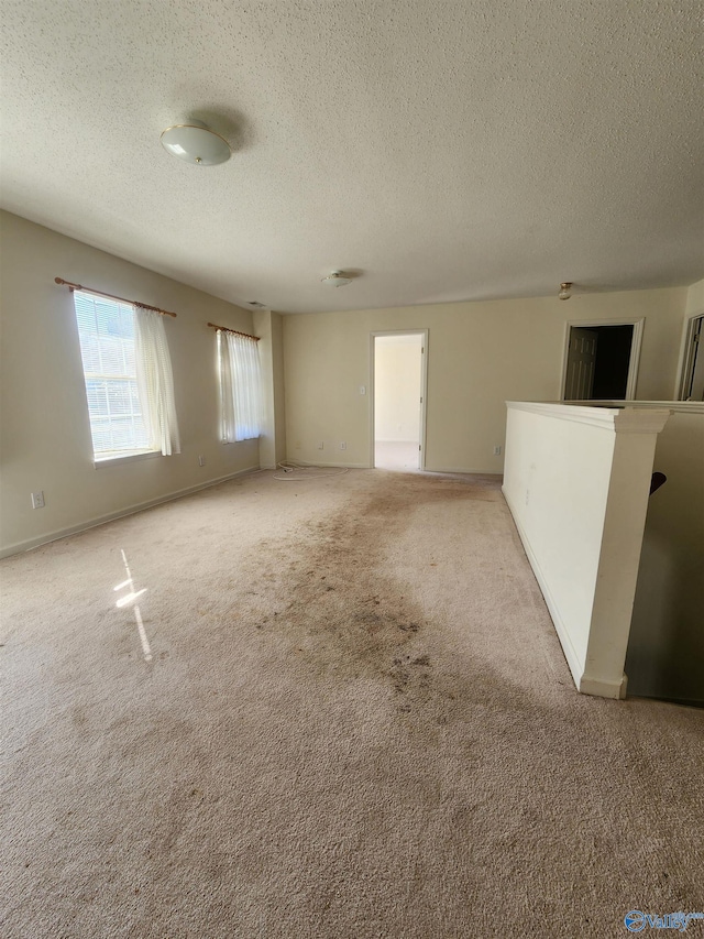 carpeted spare room with a textured ceiling