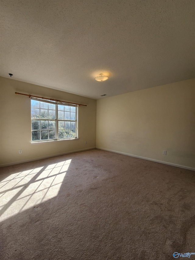 carpeted spare room featuring a textured ceiling