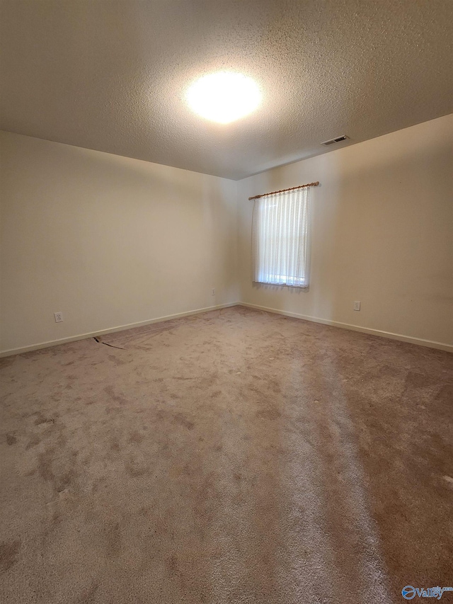 unfurnished room featuring carpet floors and a textured ceiling