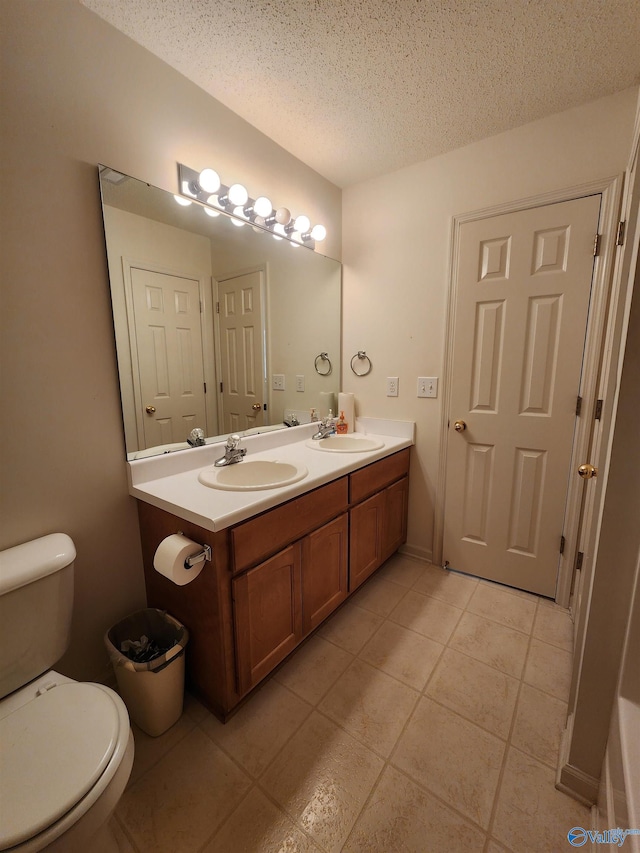 bathroom featuring tile patterned floors, vanity, a textured ceiling, and toilet