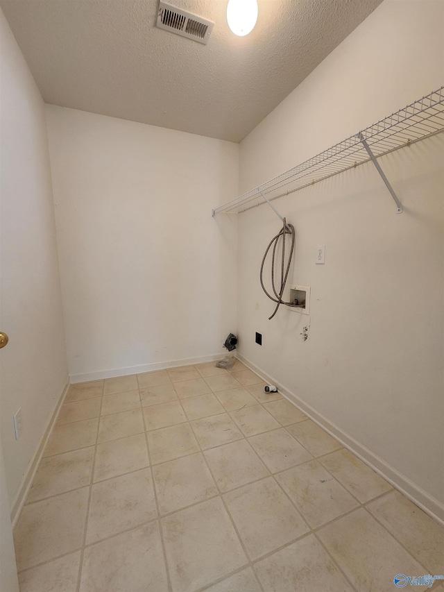 washroom with washer hookup, light tile patterned floors, and a textured ceiling