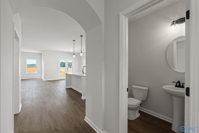 bathroom with toilet, french doors, sink, and hardwood / wood-style flooring