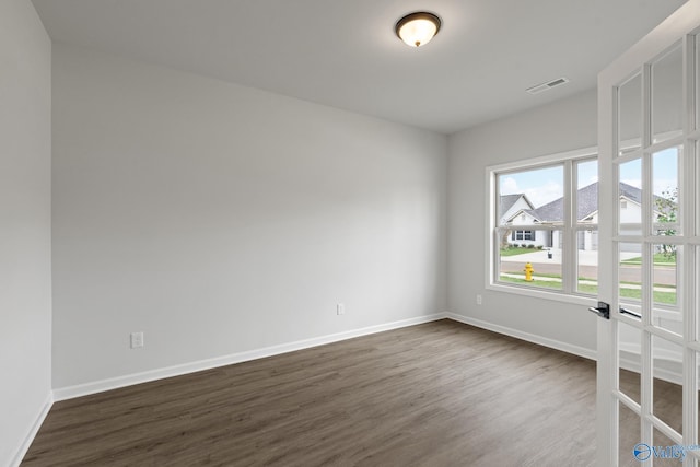 unfurnished room with dark hardwood / wood-style flooring