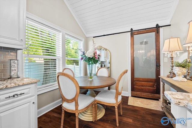 dining room featuring a barn door, dark wood-type flooring, baseboards, and vaulted ceiling