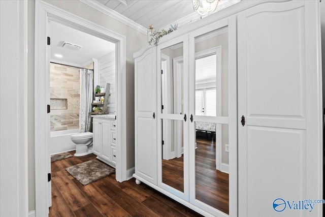full bathroom with visible vents, ornamental molding, shower / bathtub combination with curtain, vanity, and wood finished floors