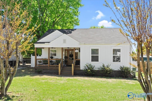 bungalow featuring roof with shingles, ceiling fan, a front yard, and fence