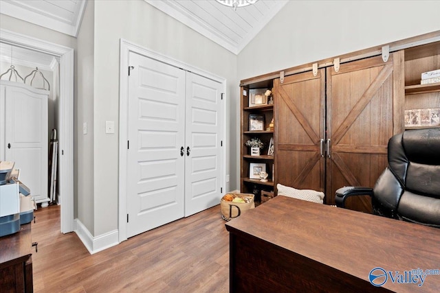 office area featuring crown molding, light wood finished floors, baseboards, and vaulted ceiling