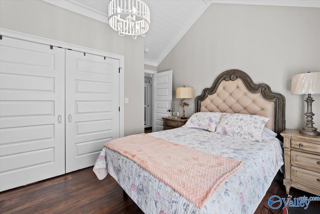 bedroom featuring a chandelier, a closet, dark wood-style floors, and lofted ceiling