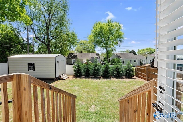view of yard with a storage shed, fence, and an outbuilding