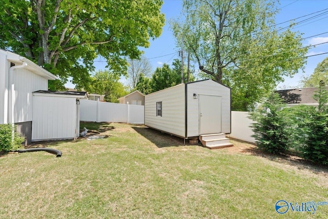 view of yard featuring an outbuilding, a shed, and a fenced backyard