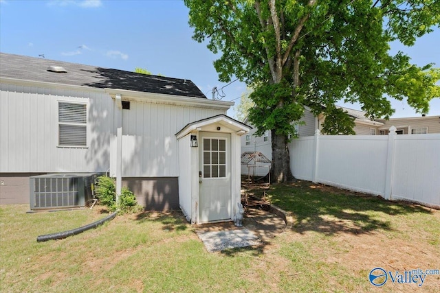 view of outbuilding with fence and central AC unit