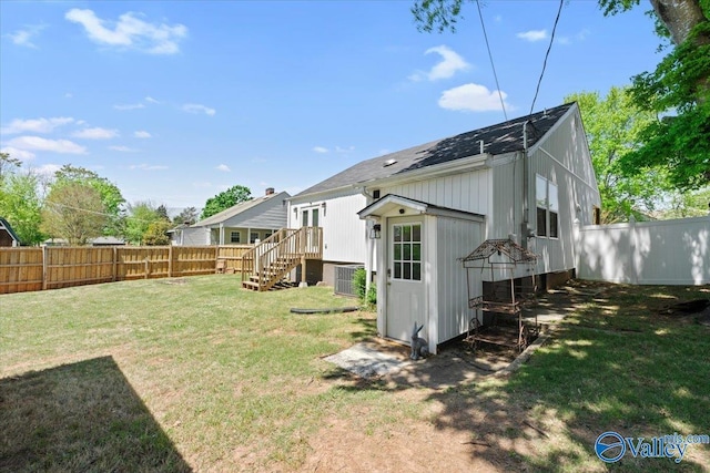 rear view of house with a yard and a fenced backyard