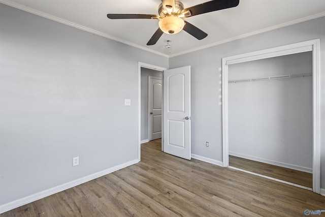 unfurnished bedroom with ceiling fan, light hardwood / wood-style floors, ornamental molding, and a closet