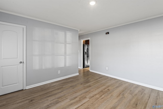 empty room with light hardwood / wood-style floors and ornamental molding