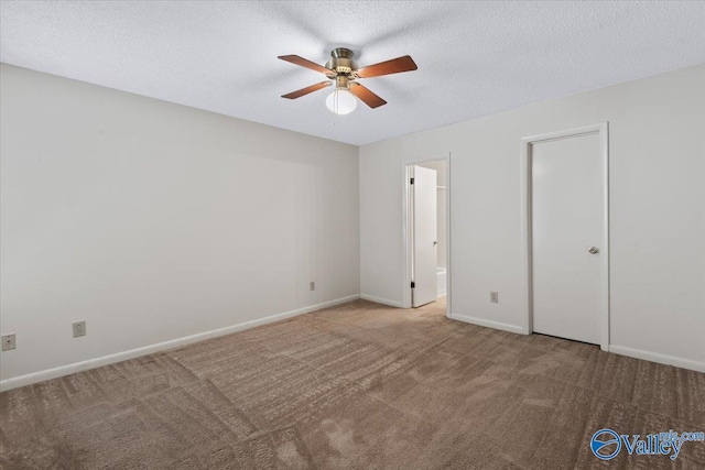 unfurnished bedroom with ceiling fan, ensuite bathroom, carpet, and a textured ceiling