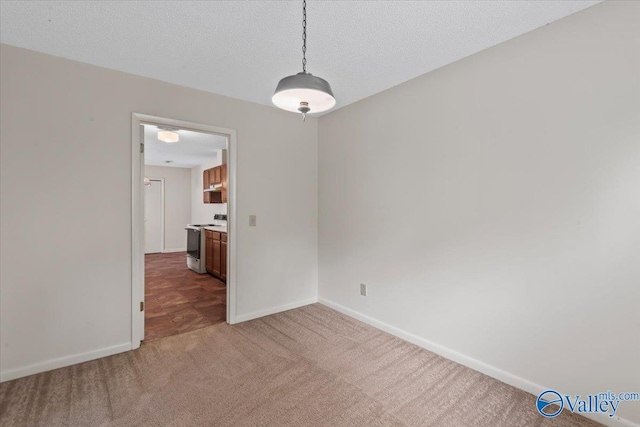 unfurnished dining area featuring light colored carpet and a textured ceiling