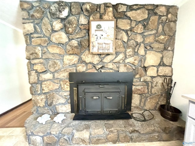 room details with baseboards, wood finished floors, and a wood stove