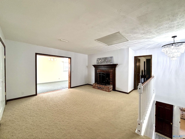 unfurnished living room featuring a textured ceiling, baseboards, a fireplace, an inviting chandelier, and light colored carpet
