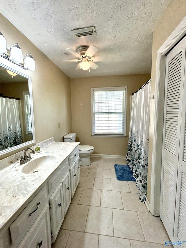bathroom featuring a closet, toilet, vanity, a ceiling fan, and visible vents