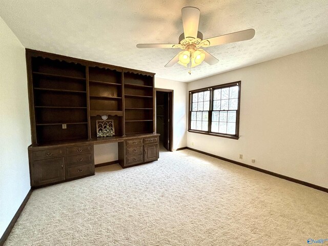 interior space with light carpet, baseboards, and a textured ceiling
