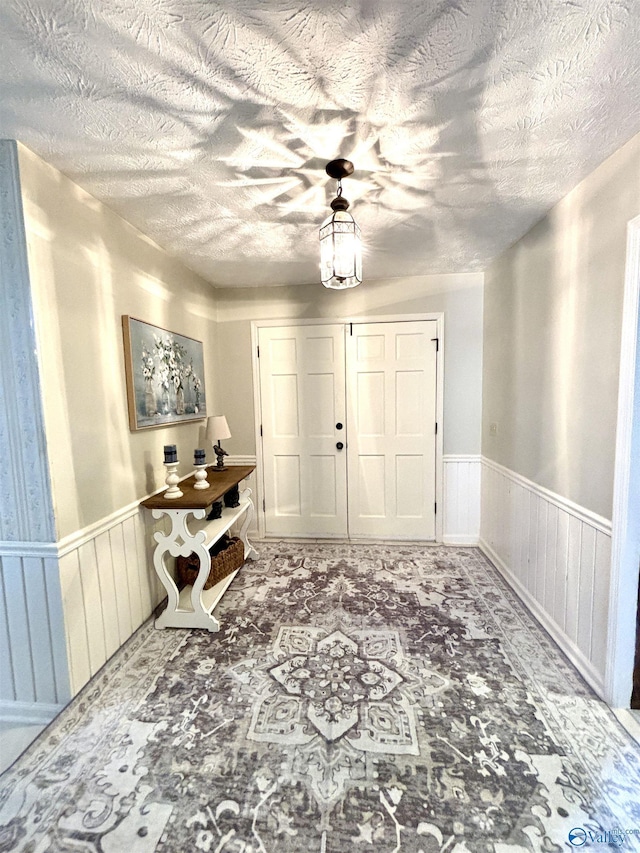 entryway featuring wainscoting and a textured ceiling