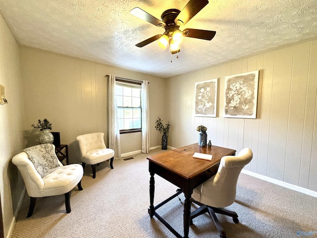 office with a textured ceiling, ceiling fan, visible vents, and light carpet