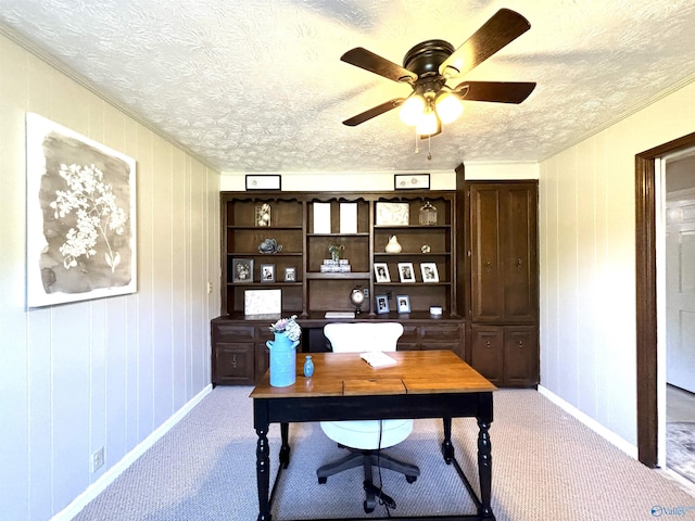 office space featuring a ceiling fan, baseboards, light colored carpet, and a textured ceiling