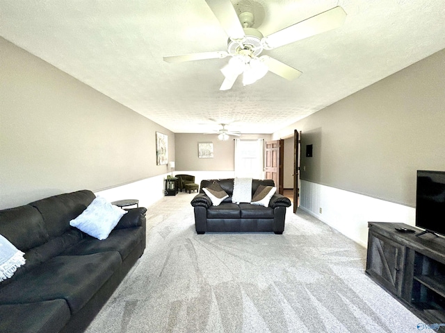 carpeted living area with a textured ceiling and a ceiling fan