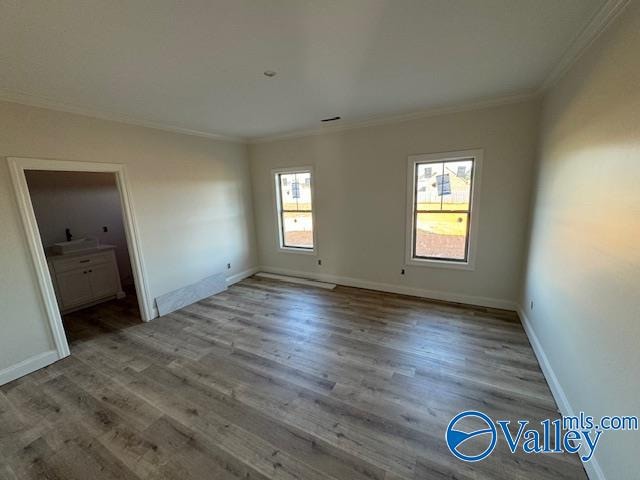 empty room featuring hardwood / wood-style floors and ornamental molding