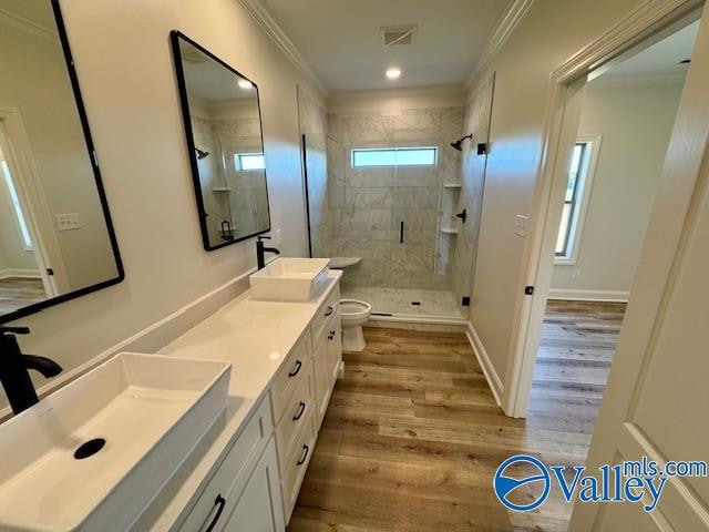 bathroom with vanity, toilet, ornamental molding, walk in shower, and wood-type flooring